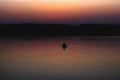 Silhouette of a man which floating on a boat on the sea at sunset time Royalty Free Stock Photo