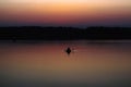 Silhouette of a man which floating on a boat on the sea at sunset time Royalty Free Stock Photo