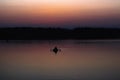 Silhouette of a man which floating on a boat on the sea at sunset time Royalty Free Stock Photo