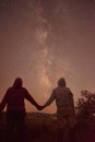 Silhouette of cross at night with beautiful milky way backgroundSilhouette of a man and a woman in love holding hands with beautif Royalty Free Stock Photo