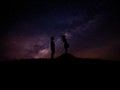 Silhouette of man and woman over grass and hill with star milky way backgrounds, romantic valentine Royalty Free Stock Photo