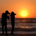 Silhouette of man and woman photographers take a sunrise picture