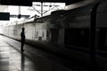 Silhouette of a man or woman on the train station in the dark. Concept of loneliness. A passenger waiting on the train