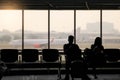 silhouette of man and woman waiting for flight Royalty Free Stock Photo