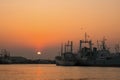 Silhouette many ships mooring on riverside against sunset sky background in evening time