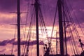 Silhouette of masts and ropes of a wooden old sailing ship against the background of the evening dark pink purple neon magical sky Royalty Free Stock Photo