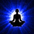 Silhouette of meditating person with blue light rays background