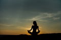 Silhouette meditation girl lotus position on stone on the background of the stunning sea. Royalty Free Stock Photo