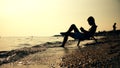 Silhouette men in chair reading book on the beach sunset Royalty Free Stock Photo
