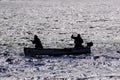 Silhouette of a men fishing from a small boat Royalty Free Stock Photo