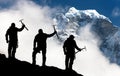 Silhouette of men with ice axe in hand and mountains Royalty Free Stock Photo