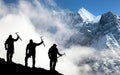 Silhouette of men with ice axe in hand and mountains Royalty Free Stock Photo