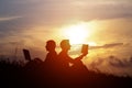 Silhouette of a men with laptop and a book on sunset or sunrise background Royalty Free Stock Photo