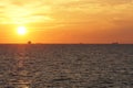 Silhouette of merchant ships on the horizon of calm Pacific ocean during sunset