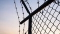 Metal mesh fence and barbed wire mesh at sunset Royalty Free Stock Photo