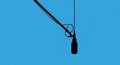 Silhouette of a microphone against a bright blue sky Royalty Free Stock Photo