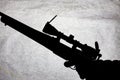 Silhouette of a military carbine on a stone background. Arms in the male hand. Shotgun for long range shooting