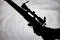 Silhouette of a military carbine on a stone background. Arms in the male hand. Shotgun for long range shooting