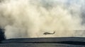 Silhouette of military helicopter landing or taking off in a dust cloud Royalty Free Stock Photo