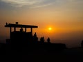 Silhouette of military post on mountain peak against sunset