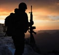 Silhouette of a military soldier with weapons at sunset Royalty Free Stock Photo