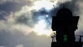 A silhouette of the minaret of Sultan Muhammad V Mosque in Labuan,Malaysia with partial solar eclipse viewed under cloudy skies o