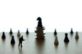 Silhouette miniature businessman pointing at horse chess piece above coin stack