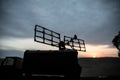 Silhouette of mobile air defence truck with radar antenna during sunset. Satellite dishes or radio antennas against evening sky Royalty Free Stock Photo