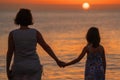 Silhouette of mom and daughter are watching the sunrise at sea. Concept of happy friendly family. Horizontal image Royalty Free Stock Photo