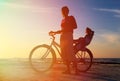 Silhouette of mother and baby biking at sunset Royalty Free Stock Photo