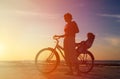 Silhouette of mother and baby biking at sunset Royalty Free Stock Photo