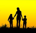 Silhouette mother and child holding hands at sunset