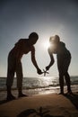 Silhouette of mother and daughter holding a starfish on the beach Royalty Free Stock Photo