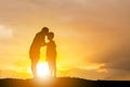 Silhouette of a mother kissing his son in a forehead on the sunset summer day Royalty Free Stock Photo