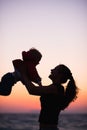 Silhouette of mother playing with baby in sunset Royalty Free Stock Photo