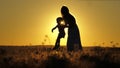 Silhouette of a mother with a small child against the sunset sky. Happy motherhood life with daughter. A woman on Royalty Free Stock Photo