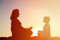 Silhouette of mother and son doing yoga on beach Royalty Free Stock Photo