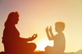 Silhouette of mother and son doing yoga on beach Royalty Free Stock Photo