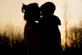 Silhouette of a mother and son playing outdoors at sunset. Mother`s day concept Royalty Free Stock Photo