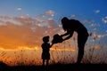 Silhouette of a mother and son playing outdoors at sunset Royalty Free Stock Photo