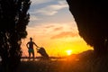 Silhouette of mother with stroller enjoying motherhood at sunset