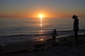 Silhouette of mother and toddler looking at sunset