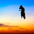 Silhouette of motocross rider jump in the sky