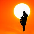 Silhouette of motocross rider jump in the sky