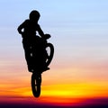 Silhouette of motocross rider jump in the sky