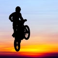 Silhouette of motocross rider jump in the sky