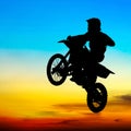 Silhouette of motocross rider jump in the sky