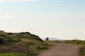 Silhouette of a motorbiker next to a road and meadow