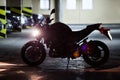 Silhouette of motorcycle standing underground parking with running engine