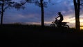 The silhouette of a motorcyclist on a background of nature, who rides the forest part on a cross or utilitarian